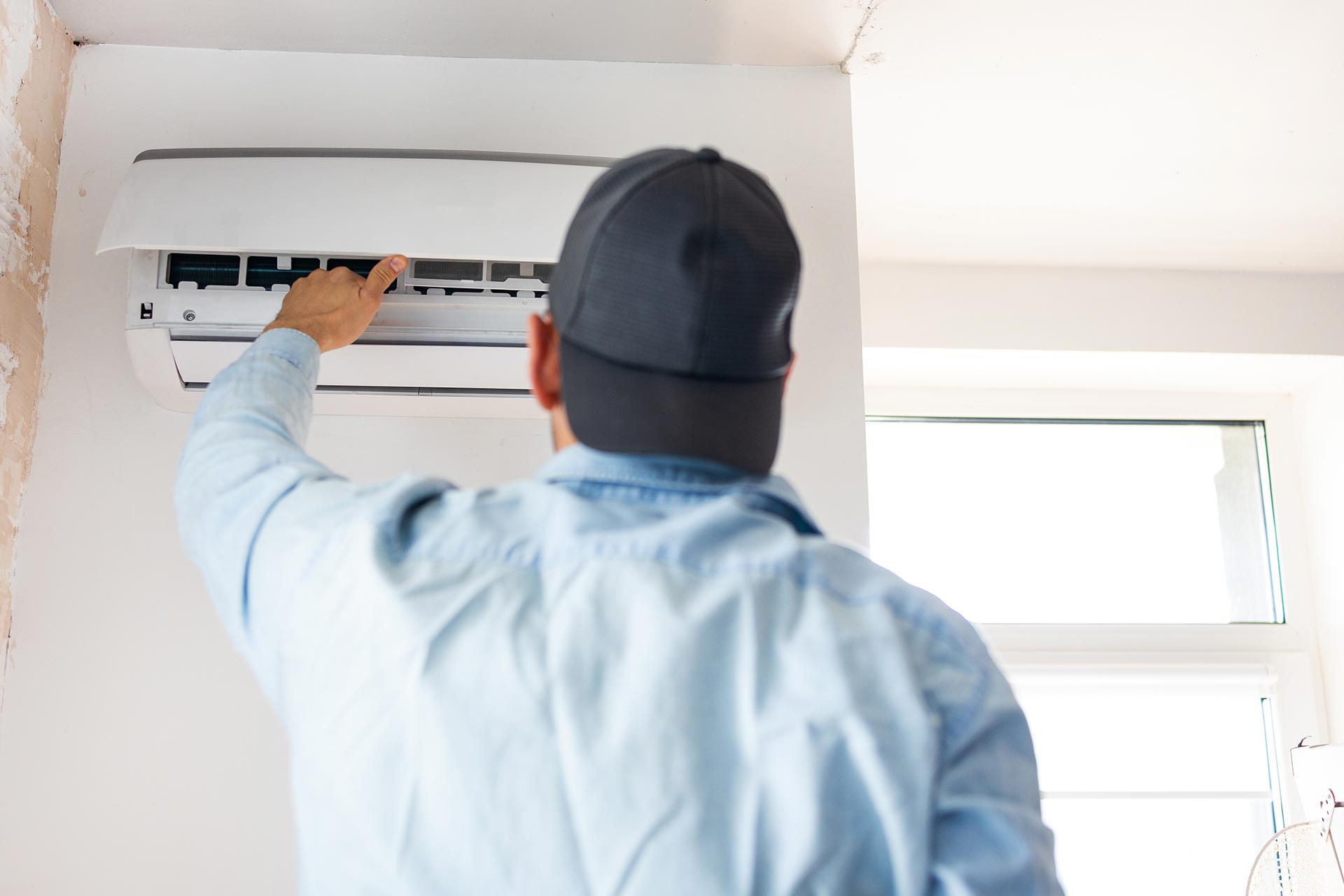 young-male-technician-repairing-air-conditioner